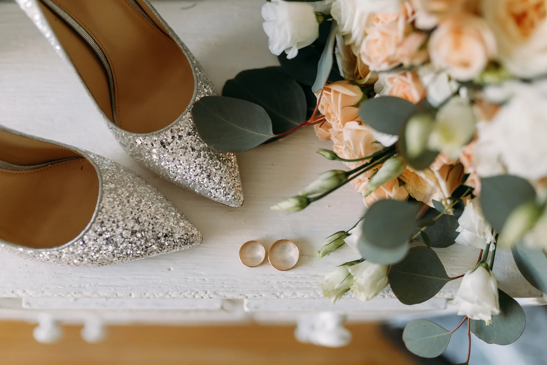 Wedding shoes and rings on a windowsill